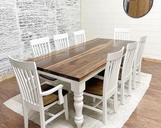 a dining room table with white chairs and a brown wooden centerpiece on top of a rug