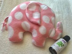 an elephant made out of pink and white polka dots next to a bottle of essential oils