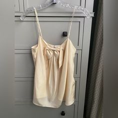 Pretty Silk Camisole, Fully Lined And Has Pretty Bow On Front And Covered Back Button Details. Beige Camisole Tank Top For Daywear, Feminine Spaghetti Strap Tops For Daywear, Beige Tank Top For Daywear, Beige Camisole Top For Daywear, Beige Cami Top For Daywear, Beige Tops With Built-in Bra For Daywear, Chic Beige Tops With Tank Straps, Beige Top With Built-in Bra For Daywear, Chic Beige Tank Top For Daywear