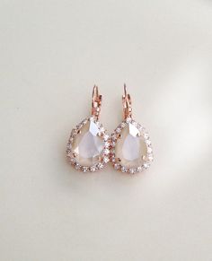 "Gorgeous pair of halo earrings featuring ivory cream crystals surrounded by a halo of sparkling clear crystals. The center stones in these are a luscious ivory color! Rose Gold plated settings, as shown. Also available in silver or gold plated. Please select desired metal finish from the drop down menu at check out. The earrings are 1 1/4\" long, 3/4\" wide Thanks for stopping by." Wedding Bridal Earrings In Rose Gold With Halo Design, Rose Gold Halo Bridal Earrings For Wedding, Delicate Teardrop Crystal Earrings For Parties, Formal White Sparkling Teardrop Earrings, White Sparkling Pear-shaped Jewelry, White Halo Setting Drop Earrings, Wedding Drop Jewelry With Halo Design, Halo Design Drop Jewelry For Wedding, Halo Design Drop Wedding Jewelry