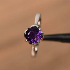 It is a natural amethyst ring, round cut, measures 7mm*7mm, weight about 1.25 cts. The basic metal is sterling silver and plated with rhodium.To change the metal to a solid gold (white/rose) or platinum is also available, please ask for a quotation if you want.You can also go to my shop Home for more elegant rings: https://www.etsy.com/shop/godjewelry?ref=hdr_shop_menuamethyst is the birthstone of February. More amethyst rings:https://www.etsy.com/shop/godjewelry?ref=seller-platform-mcnav&se Elegant Round Amethyst Birthstone Ring, Elegant Amethyst Birthstone Ring, Purple Solitaire Birthstone Ring, White Gold Amethyst Birthstone Ring With Round Cut, Purple Birthstone Ring With Prong Setting, Round Cut White Gold Amethyst Birthstone Ring, Silver Amethyst Round Promise Ring, Silver Amethyst Ring With Birthstone In Round Cut, Amethyst Solitaire Birthstone Ring, Round Cut