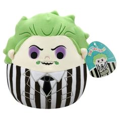 a stuffed toy with a green hair and purple eyes wearing a black and white striped suit