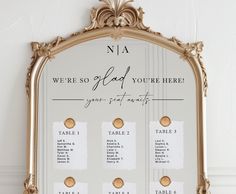 a gold framed mirror with seating cards on it