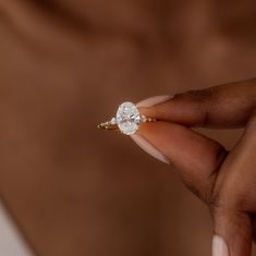 a woman's hand holding a diamond ring