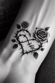 a black and white photo of a rose tattoo on the foot, with leaves around it