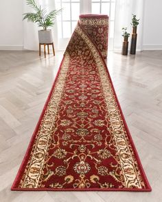 a red rug with gold border on the floor