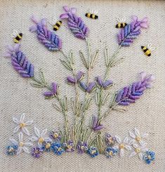 some flowers and bees are on a piece of fabric with stitching in the middle