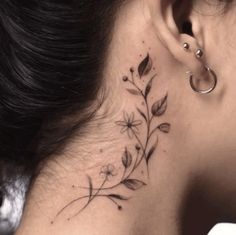 a woman's behind the ear tattoo with flowers