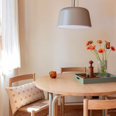 a wooden table with flowers in a vase on top of it next to a window