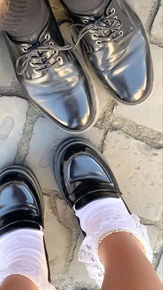 two people standing next to each other wearing black shoes and white socks with lace on them