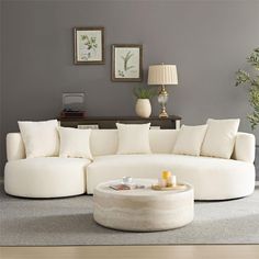 a living room filled with furniture and a white round couch on top of a hard wood floor