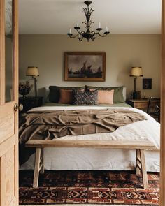 a bedroom with a bed, chandelier and pictures on the wall above it