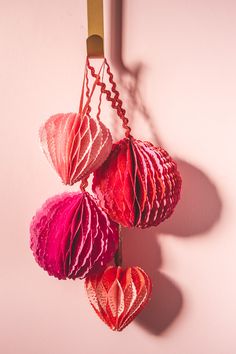 three red and pink hearts hanging from a hook