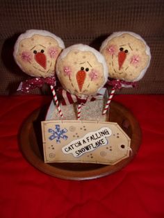 three stuffed turkeys sitting on top of a wooden bowl with candy canes in it