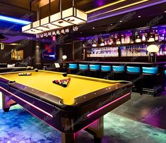 a pool table in the middle of a room with blue chairs and lights on it