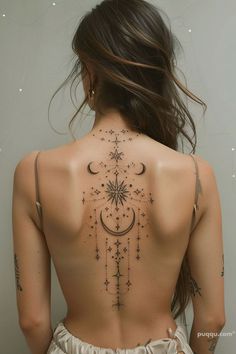 the back of a woman's body with stars and moon tattoos