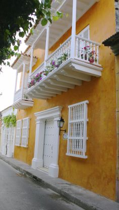 an orange building with white balconies and flowers