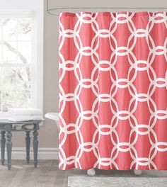 a bathroom with a shower curtain that has circles on it in pink and white colors