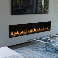 a living room with a glass coffee table and fire place in front of the fireplace