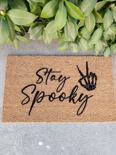 a door mat with the words stay spooky written in black ink on it