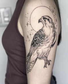 a woman with a tattoo on her arm has a hawk and the moon behind it