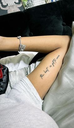 a woman laying on top of a bed with her legs crossed and the words, not that is awesome written on her leg