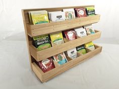 a wooden shelf holding several different types of coffees and tea bags on it's sides