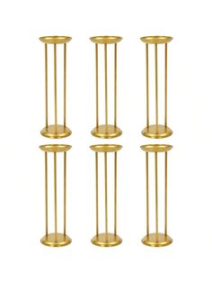 four brass candlesticks are lined up against a white background