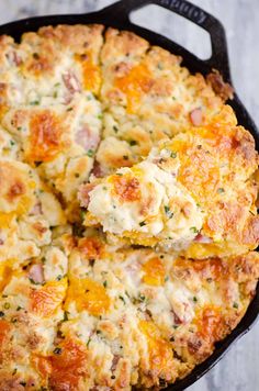 a cheesy casserole is being lifted from the skillet