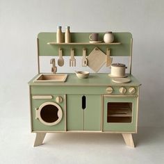 a green toy kitchen set with sink, stove and oven