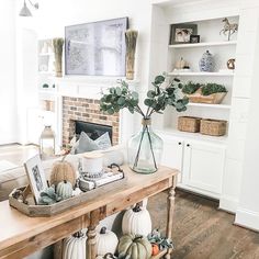 a living room filled with furniture and a fire place covered in pumpkins on top of a wooden table