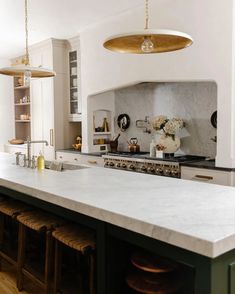 a kitchen with marble counter tops and stools in front of the stove top oven