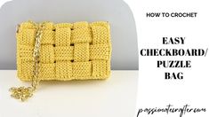 a crocheted yellow purse sitting on top of a white table next to a chain