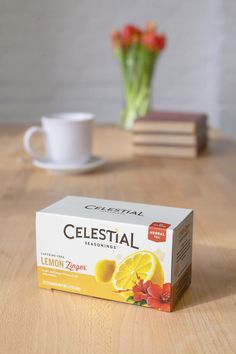 a box of celestal sitting on top of a table next to a cup