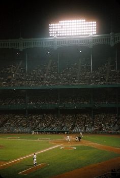 a baseball game in progress with the batter up to plate ready for the pitch at night