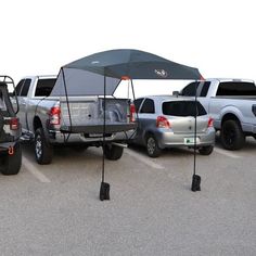 four pickup trucks parked in a parking lot with an umbrella over the back seat area