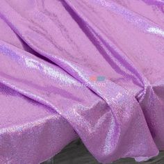 the fabric is shiny purple and has a large amount of glitter on it's surface