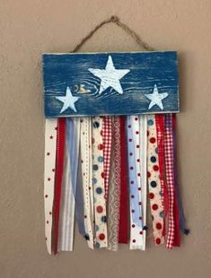 an american flag made out of ribbon hanging from a wall with stars and stripes on it