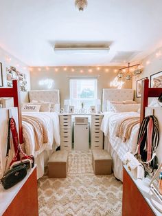 two beds in a small room with lights on the ceiling and pictures hanging above them