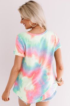 Steal the show with our vibrant "Mai Tai Time" tee featuring soft lightweight material patterned with neon pink, blue, yellow, and green tie dye, a scooped neckline that can be worn off one shoulder, short loose sleeves with tolled cuffs, an accent chest pocket, and a relaxed silhouette that falls into a rounded hemline that can be knotted! We have styled this summer cutie with some distressed denim shorts and trendy sneakers, but you can also wear it with some white flares, clear sandals, and a Summer Tie Dye T-shirt With Rainbow Print, Summer Multicolor T-shirt With Rainbow Print, Tie Dye Short Sleeve Top For Summer, Multicolor Rainbow Print T-shirt For Summer, Trendy Rainbow T-shirt For Summer, Blue Tops With Rainbow Print For Spring, Blue Top With Rainbow Print For Spring, Trendy Rainbow Summer T-shirt, Multicolor Rainbow Print T-shirt For Spring