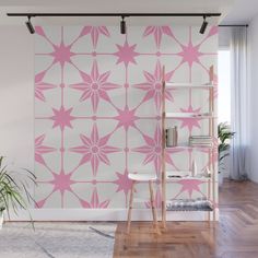 a pink and white wallpaper with stars on it in a living room next to a book shelf