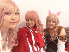 three women are posing for the camera in front of a wall with bunny ears on it