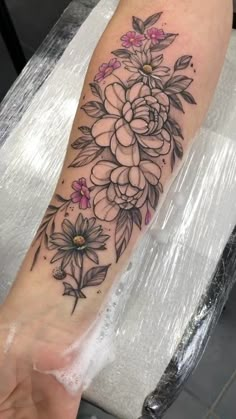 a woman's arm with flowers on it