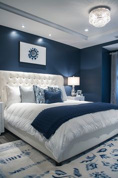 a bedroom with blue walls and white bedding, chandelier, rugs