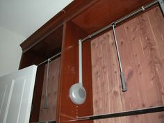 a bathroom with wooden cabinets and white toilet paper dispenser on the wall