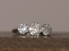 three stone diamond ring sitting on top of a table