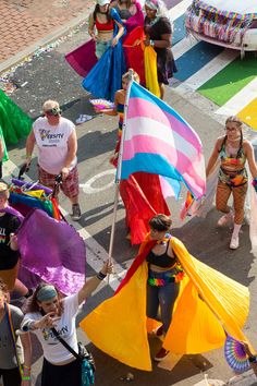 a group of people walking down a street holding flags