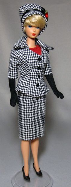 a barbie doll wearing a black and white suit