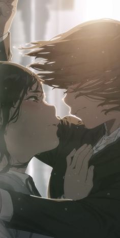 two people are kissing each other in front of the sun shining down on them and their hair blowing back