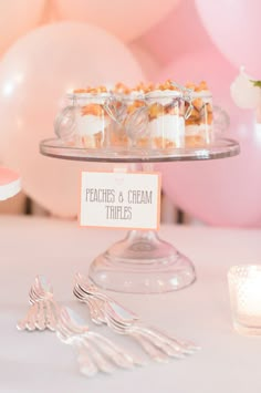 desserts and forks on a table with balloons in the background